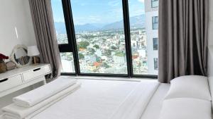 a bedroom with a white bed and a large window at 1932 OC2a in Nha Trang