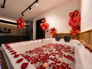 a bath tub filled with red roses and balloons at Villa Vrosi - فلل وأكواخ فيروز السياحية in Ardeşen +21 photos