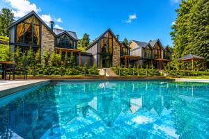 an estate with a swimming pool in front of a house at Villa Vrosi - فلل وأكواخ فيروز السياحية in Ardeşen