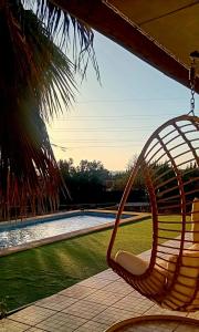 a hammock hanging from a porch next to a pool at AuraHouse Algarve in Lagoa
