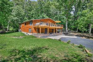 a large log cabin in the woods with a balcony at Covea Cabin in Luray