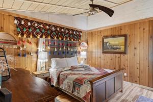 a bedroom with a bed in a room with wooden walls at Covea Cabin in Luray