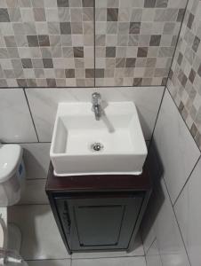 a bathroom with a white sink and a toilet at Arbis Jusseth Home in Calobrito +6 photos