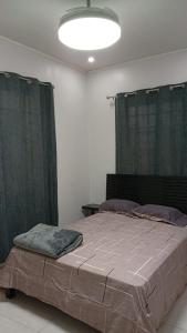 a bedroom with a large bed with green curtains at Arbis Jusseth Home in Calobrito
