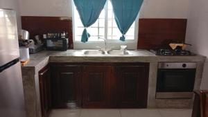 a kitchen with a sink and a window at Arbis Jusseth Home in Calobrito