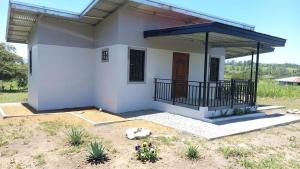 a small house with a balcony in a yard at Arbis Jusseth Home in Calobrito