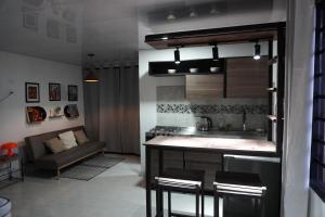 a living room with a kitchen and a couch at Loft Del Ruiz - Apartamentos in Líbano