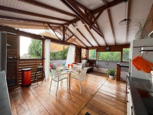 a kitchen and dining room with a table and chairs at Chalet du Soleil in Pointe-Noire