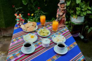 a table with food and cups of coffee and juice at TuKasa Boutique Liberdad - Buen cafe en Terraza Interior in Ayacucho