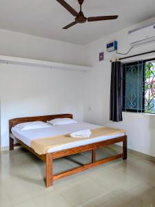 a bedroom with a bed and a ceiling fan at shivkrupa Guest house in Arambol