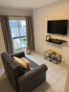 a living room with a couch and a flat screen tv at Dpto del Cerro in Tandil