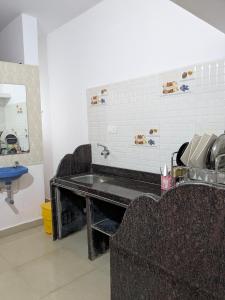 a bathroom with a sink and a couch and a mirror at shivkrupa Guest house in Arambol