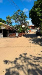 a dirt road with a building and trees on a street at cantinhoannajullyaatins in Atins