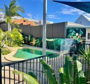 a mural on the side of a building with a swimming pool at Nambour Heights Motel in Nambour +12 photos