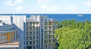 an apartment building with the ocean in the background at VacationClub - Diune Apartment 67 in Kołobrzeg
