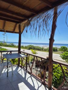 a porch with a table and a view of the beach at Vaimoe Lodge à Rangiroa sur Tiputa in Tiputa