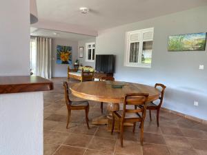 a living room with a wooden table and chairs at La Marlyse in La Vatable