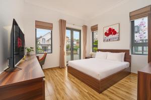a bedroom with a bed and a flat screen tv at KP Villa Dalat in Da Lat
