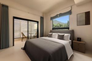 a bedroom with a large bed and a large window at Nanxiang Shushan Hotel in Sanya