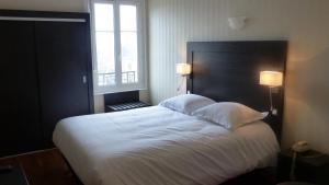 a bedroom with a large white bed with two pillows at Hotel De L'Europe in Toul