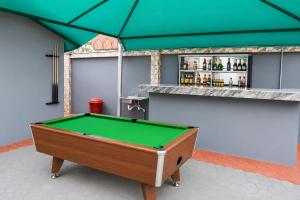 a green pool table in front of a bar at Luxury Deluxe 1 Bed, 1 Bath in Otta