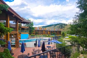 a resort with a pool and tables and umbrellas at Silver Lodge A & B in Granby
