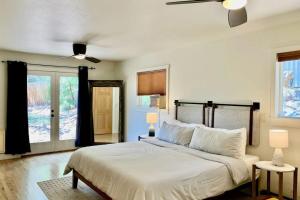 a bedroom with a bed and two windows and a ceiling fan at Hermosa Hideaway in Durango