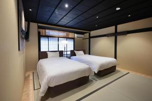 a bedroom with two beds and a window at 御宿 凪ぐ Takayama in Takayama
