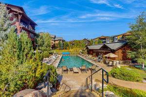 a pool at a resort with chairs and a building at Flat Tops 2510 in Steamboat Springs