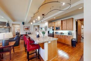 a kitchen with a large island with red chairs at The Lodges 1145 in Mammoth Lakes