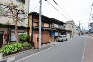a white car parked next to a building on a street at 御宿 凪ぐ Takayama in Takayama