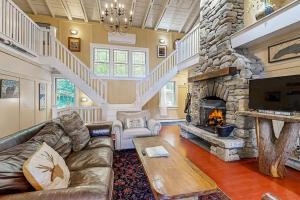 a living room with a couch and a stone fireplace at Lakeside Elegance in Tyson