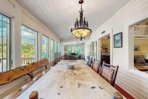 a dining room with a wooden table and a chandelier at Lakeside Elegance in Tyson