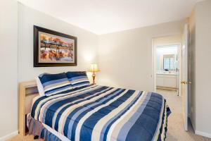 a bedroom with a blue and white striped bed at The Summit 207 in Old Mammoth +87 photos
