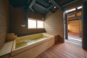 a bath tub in a wooden room with a window at 御宿 凪ぐ Takayama in Takayama +24 photos