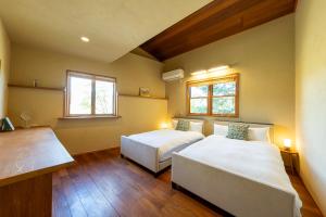 a bedroom with two beds and two windows at CALL92Chalet in Hakuba