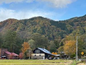a small house in front of a mountain at CALL92Chalet in Hakuba