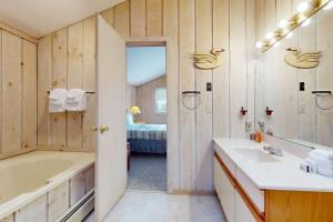 a bathroom with a tub and a sink and a bed at West Dover Getaway in West Dover +35 photos