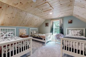 a bedroom with two beds and a wooden ceiling at Kenny in Wolfeboro