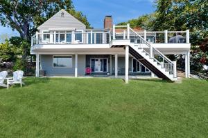 a house with a large yard with a deck at Magnolia Tides in Gloucester