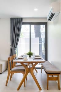 a dining room with a table and chairs and a window at Tiva Residence Bangkok in Bangkok