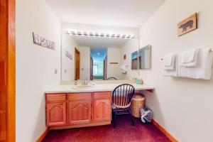a bathroom with a sink and a mirror and a chair at Relaxing on the River in Lincoln +27 photos