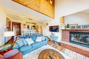 a living room with a blue couch and a fireplace at The Summit: 46 in Warren
