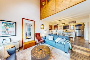 a living room with a blue couch and a table at The Summit: 46 in Warren