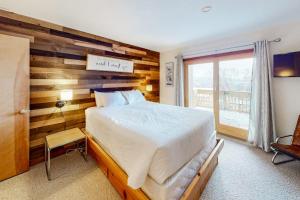 a bedroom with a bed and a wooden wall at The Summit: 46 in Warren