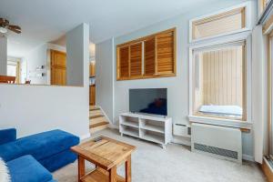 a living room with a blue couch and a tv at Sugar Run 34 in Sugarbush Village