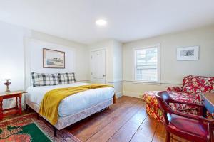 a bedroom with a bed and a couch and a chair at Bayberry Farmhouse in Weston