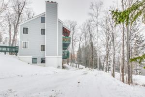 a building on a snow covered road with trees at Okemo Trailside 08E in Ludlow