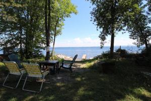a table and chairs sitting next to the water at North End Nook in North Hero
