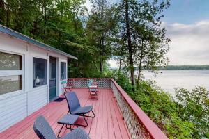 a house with chairs and a deck with a view of the water at Garden Island's Oak in Charlotte